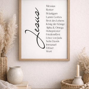 Puede incluir: Una impresi&oacute;n enmarcada con la palabra "Jes&uacute;s" en cursiva y una lista de palabras alemanas. El marco es de color marr&oacute;n claro. La impresi&oacute;n est&aacute; sobre un fondo blanco. La impresi&oacute;n est&aacute; rodeada de elementos decorativos, como un jarr&oacute;n, una vela y una cesta.
