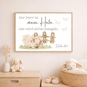 Könnte beinhalten: Ein gerahmter Druck mit einer Aquarellillustration eines Schafs, das sich in der Nähe eines Holzzauns ausruht. Der Druck enthält den Text "Der Herr ist mein Hirte, mir wird nichts mangeln" und "Psalm 23.1". Sanfte, neutrale Farben.