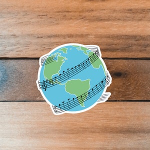 May include: A blue and green globe with musical notes wrapped around it. The globe is on a woodgrain background.