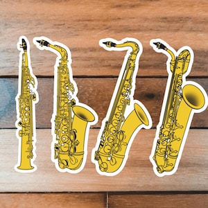 May include: Four yellow saxophone stickers on a wood background. The saxophones are different sizes and styles.