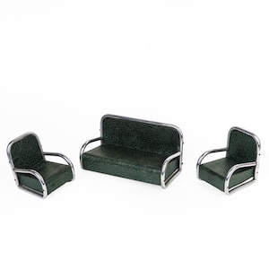May include: A miniature furniture set featuring a dark green sofa and two matching armchairs. The set has a retro design with silver-colored metal frames. The upholstery has a textured pattern.