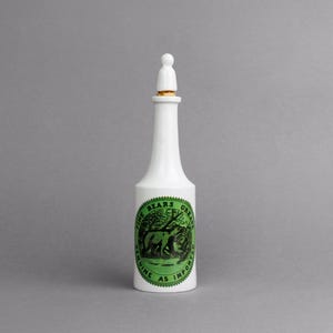 May include: White ceramic bottle with a green and black label that reads "Fine Bears Grease Genuine as Imported".