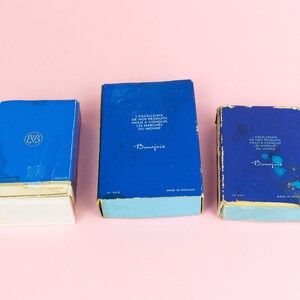 Puede incluir: Tres cajas azules con bordes blancos y letras doradas. Las cajas est&aacute;n etiquetadas "Beaujolais" y contienen el texto "L'Excellence de nos Produits nous a Conquis les Marches du Monde".