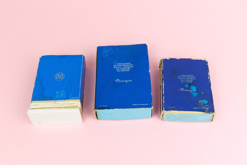 Puede incluir: Tres cajas azules con bordes blancos y letras doradas. Las cajas est&aacute;n etiquetadas "Beaujolais" y contienen el texto "L'Excellence de nos Produits nous a Conquis les Marches du Monde".