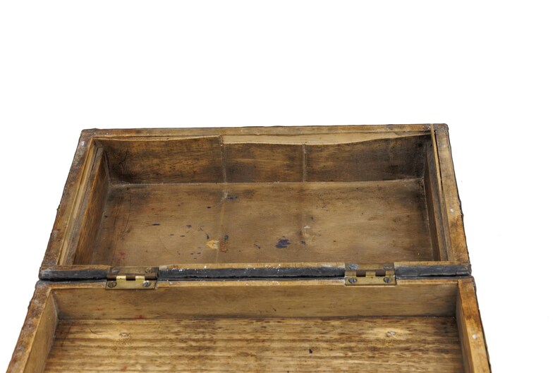 May include: An open, rectangular wooden box with a hinged lid. The box is made of light brown wood with visible grain and a distressed finish. The interior is also wooden, with brass hinges.