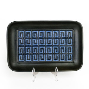 May include: Black rectangular ceramic serving tray with a blue and black geometric pattern.