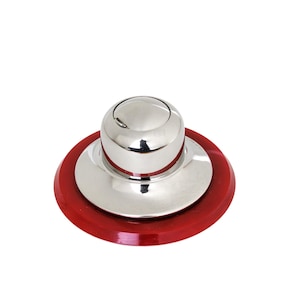 May include: A circular object featuring a polished, reflective silver-tone metal dome centred on a flat, vibrant red base. The metallic component has a smooth, rounded top and a wider, flat circular flange that rests directly against the red disc.