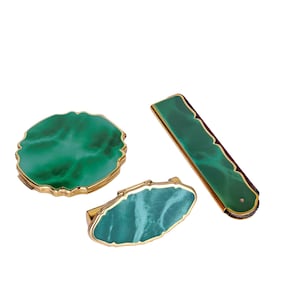 May include: A set of three ceramic mugs with a speckled, matte finish. The mugs are in cream, light grey, and dark grey. Each mug has a simple, minimalist design, ideal for coffee or tea.