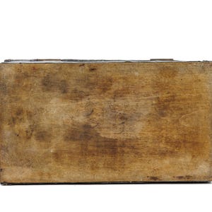 May include: A rectangular wooden box with a distressed, aged appearance. The wood has a warm, brown tone with visible grain and darker areas, suggesting age and use. The box is viewed from above, showcasing its simple, sturdy construction.