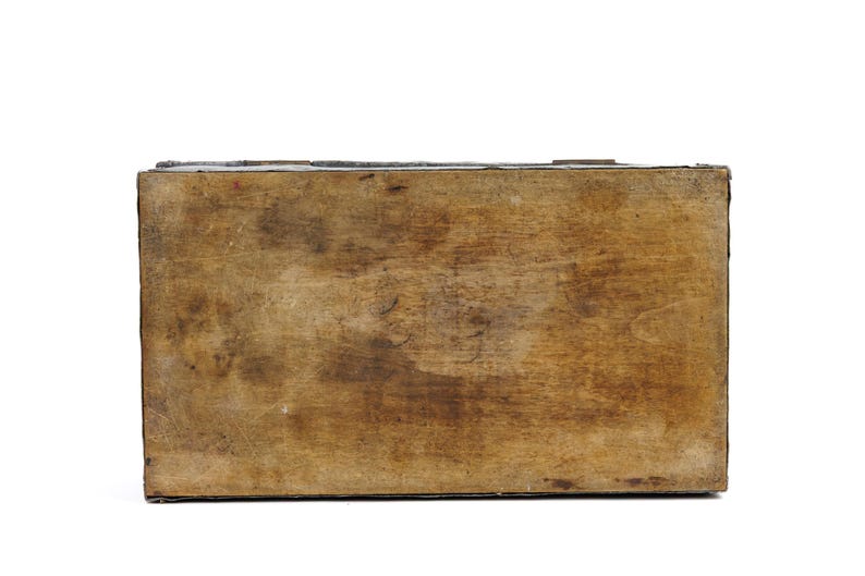 May include: A rectangular wooden box with a distressed, aged appearance. The wood has a warm, brown tone with visible grain and darker areas, suggesting age and use. The box is viewed from above, showcasing its simple, sturdy construction.