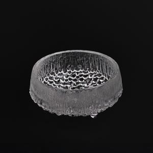 May include: A clear glass bowl with a textured, raised design. The bowl is round and has a slightly flared rim.