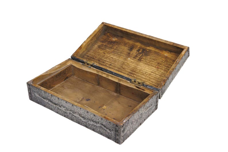 May include: An open wooden box with a hinged lid. The box is rectangular with a light brown interior and a textured, gray exterior. The lid is slightly ajar, revealing the inside of the box.