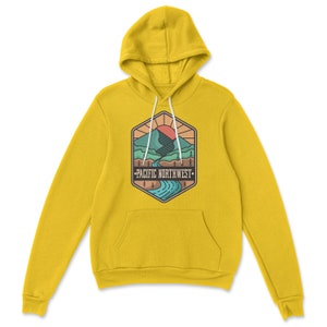 May include: Yellow hoodie with a graphic of a mountain range, a river, and a sun with the text "PACIFIC NORTHWEST" in a hexagon.