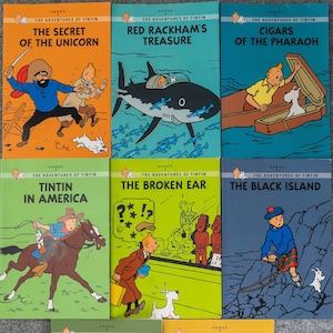 May include: A collection of eight vintage comic books featuring the adventures of Tintin. The covers feature colourful illustrations of Tintin and his dog Snowy in various settings, including a pirate ship, a jungle, and a desert.