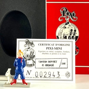 May include: A certificate of origin for a Pixi-Mini figurine of Tintin from the Tintin Soviet comic book series. The certificate is printed on a white card with black text and a red border. The certificate number is 002943. The certificate is in a white box with a black interior.