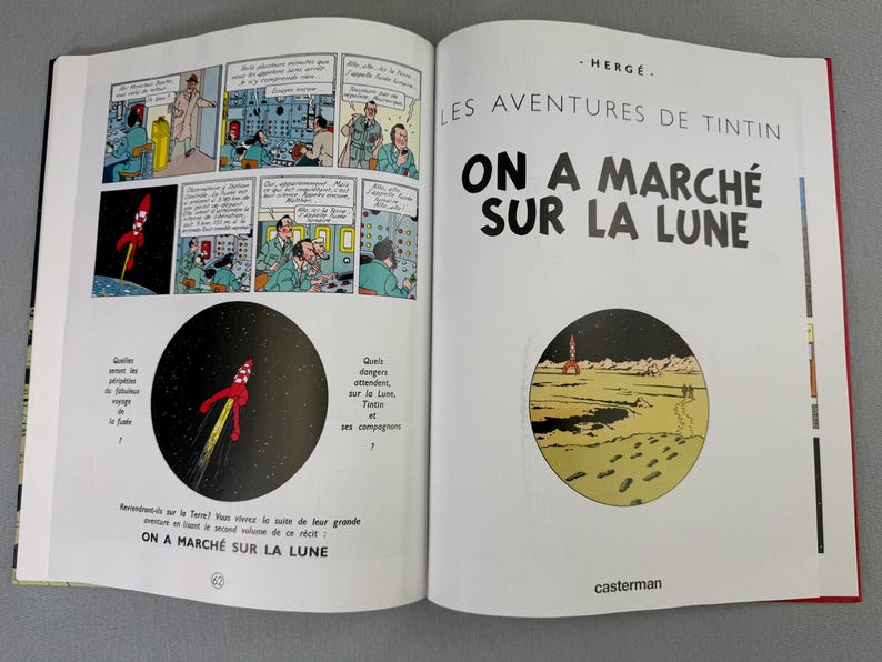 Puede incluir: Libro abierto con ilustraciones de c&oacute;mic de un lanzamiento de cohete y astronautas. El t&iacute;tulo "ON A MARCH&Eacute; SUR LA LUNE" es visible. Es una aventura de Tint&iacute;n, con el logo de la editorial.