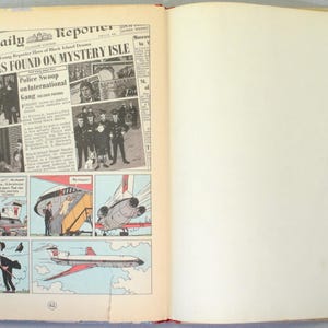 K&ouml;nnte beinhalten: Offenes Buch mit Comicstrip und Schlagzeilen. Die Schlagzeile lautet &bdquo;Forgers Found on Mystery Isle&ldquo;. Der Comicstrip zeigt Illustrationen von Personen und einem Flugzeug. Das Buch ist auf Seite 62 ge&ouml;ffnet.