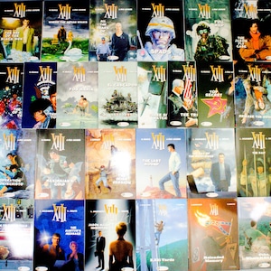 May include: A collection of comic books featuring the title "XIII" in white, with various cover illustrations. The covers display a range of colors and scenes, including action-oriented images and portraits. The books are arranged in multiple rows.