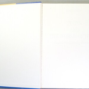 Puede incluir: Libro abierto con p&aacute;ginas blancas y cubierta azul. El texto de la p&aacute;gina derecha es apenas visible. El lomo del libro es azul con un borde superior amarillo. El libro est&aacute; abierto, mostrando dos p&aacute;ginas blancas.