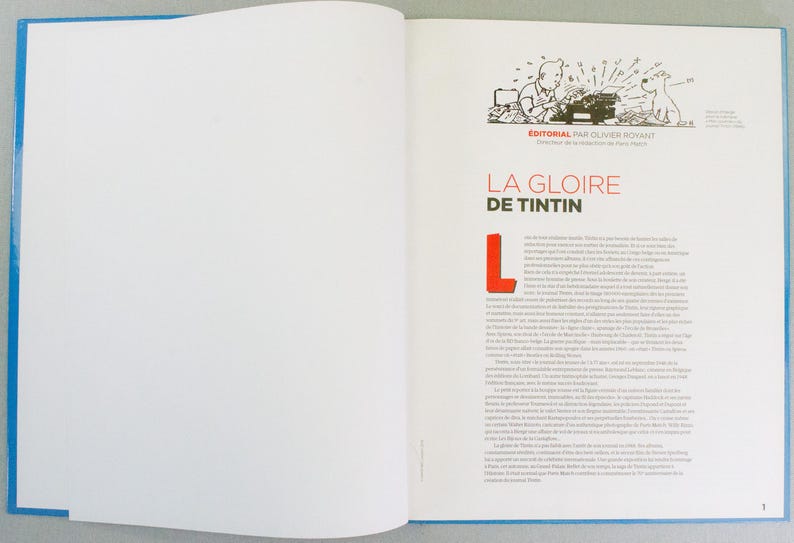 May include: Open book with a blue border. The right page features text in French with the title "LA GLOIRE DE TINTIN" in red. An illustration of a man typing on a typewriter with a dog is at the top.