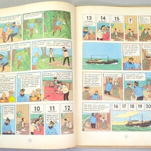 May include: Open book with comic strip illustrations. The pages feature panels with sequential art, including characters in various scenes. Numbers 10-22 are visible, along with the days of the week. The artwork is colorful and detailed.