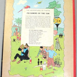 Op de afbeelding: Achterkant van het boek "De avonturen van Kuifje: De Zonnetempel". De kleurrijke illustratie toont Kuifje, Kapitein Haddock en Bobbie. De tekst beschrijft het verhaal en andere titels in de serie.