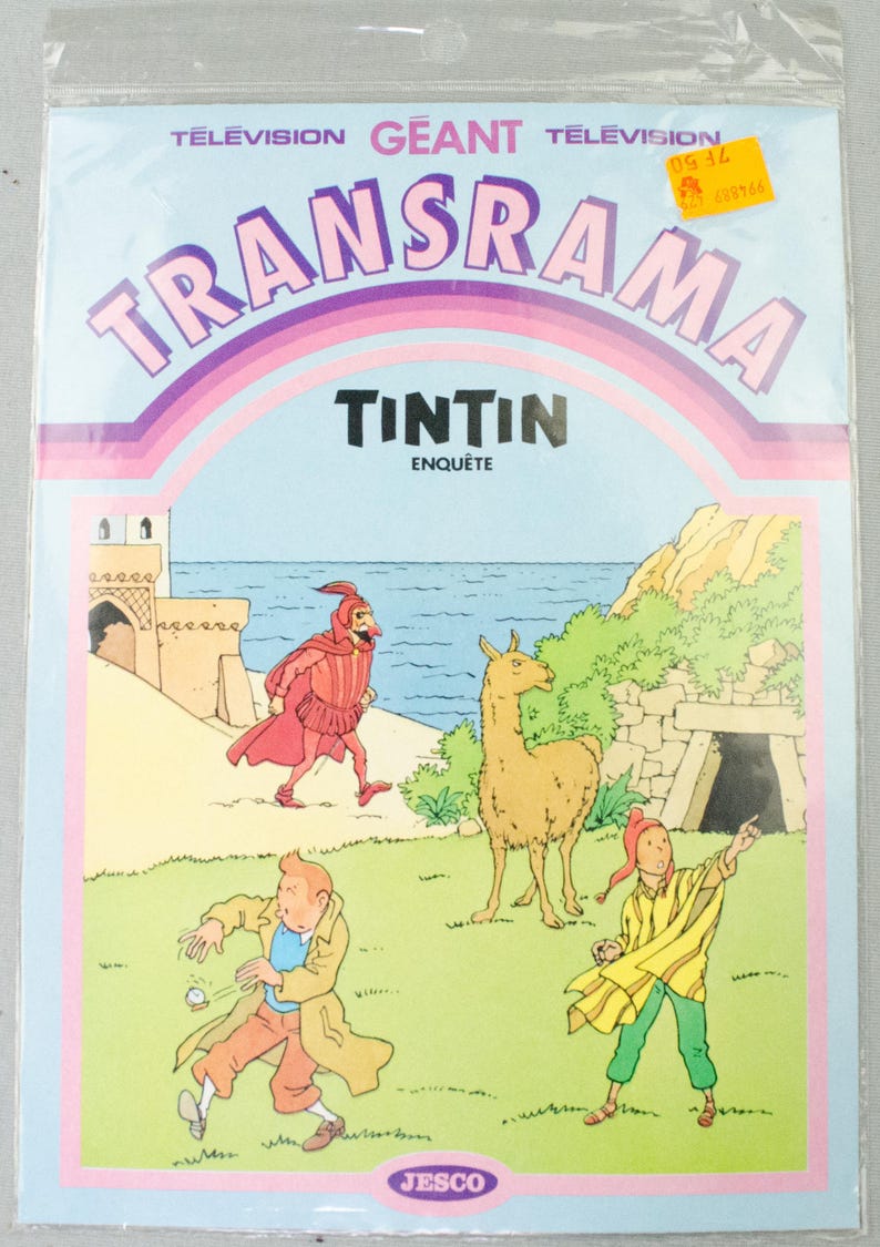 K&ouml;nnte beinhalten: Versiegelte Verpackung mit einem Comic-Cover mit dem Titel "TRANSRAMA" in gro&szlig;en, lila Buchstaben. Das Cover-Artwork zeigt Charaktere aus der "Tim und Struppi"-Serie, darunter Tim selbst, ein Lama und andere Figuren in einer farbenfrohen Au&szlig;enszene.