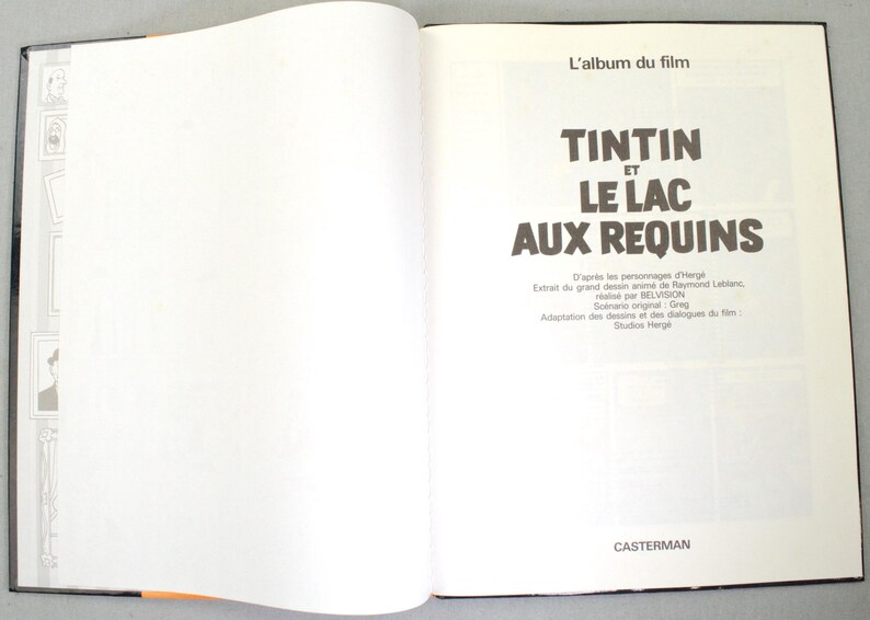 May include: Open book with the title page of a Tintin comic book. The title reads "TINTIN ET LE LAC AUX REQUINS" in large, bold letters. The book is open to a double-page spread with text and illustrations.
