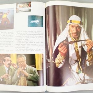 Puede incluir: Una p&aacute;gina doble de una revista vintage con fotogramas de pel&iacute;culas. Una imagen muestra a un hombre con vestimenta de Oriente Medio sosteniendo una pipa. Otras im&aacute;genes muestran un barco y dos hombres con trajes.