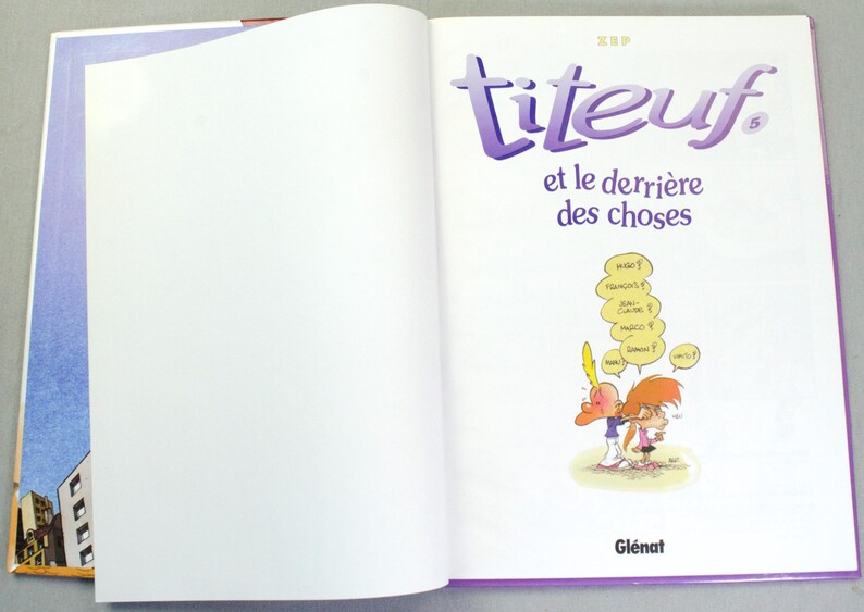 K&ouml;nnte beinhalten: Ein gebundenes Comicbuch mit dem Titel Titeuf et le derri&egrave;re des choses, Band 5. Die wei&szlig;e Titelseite zeigt violetten Text und eine kleine Comic-Illustration von zwei Figuren mit gelben Sprechblasen, die verschiedene Namen enthalten.