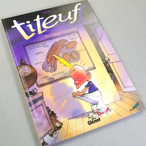 Puede incluir: Un c&oacute;mic de Titeuf titulado Dieu, le sexe et les bretelles de Zep. La portada muestra a un personaje de dibujos animados con un mech&oacute;n de pelo amarillo mirando dentro de sus pantalones blancos, ante un diagrama anat&oacute;mico Education Sexuelle.