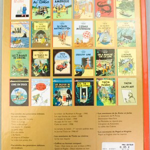 Może przedstawiać: Kolekcja komiks&oacute;w Tintina, prezentująca r&oacute;żne przygody z kolorowymi okładkami. Widoczne są grzbiety, z tytułami takimi jak "Tintin w Ameryce" i "Niebieski Lotos". Książki ułożone są na jasnopomarańczowym tle.