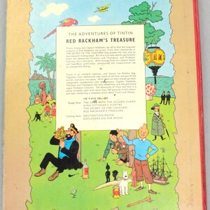 May include: The back cover of a vintage comic book titled "The Adventures of Tintin: Red Rackham's Treasure." The cover features colorful illustrations of characters and scenes from the story, including Tintin, Snowy, and Captain Haddock. The book is in English.