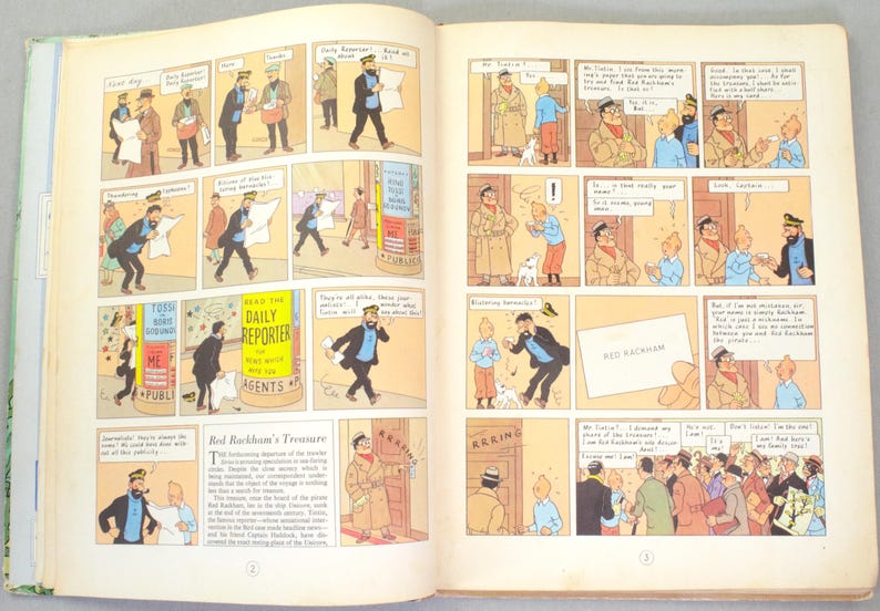 May include: Open book with comic strip illustrations. The panels depict scenes with characters in various settings, including a newspaper stand with the text "DAILY REPORTER". The comic strip is titled "Red Rackham's Treasure".