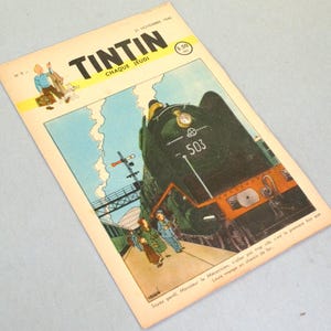 May include: A vintage Tintin comic magazine cover dated 21 November 1946, featuring a large dark green steam locomotive numbered 503 at a train station. The illustration includes a small figure of Tintin and his dog, with French text.