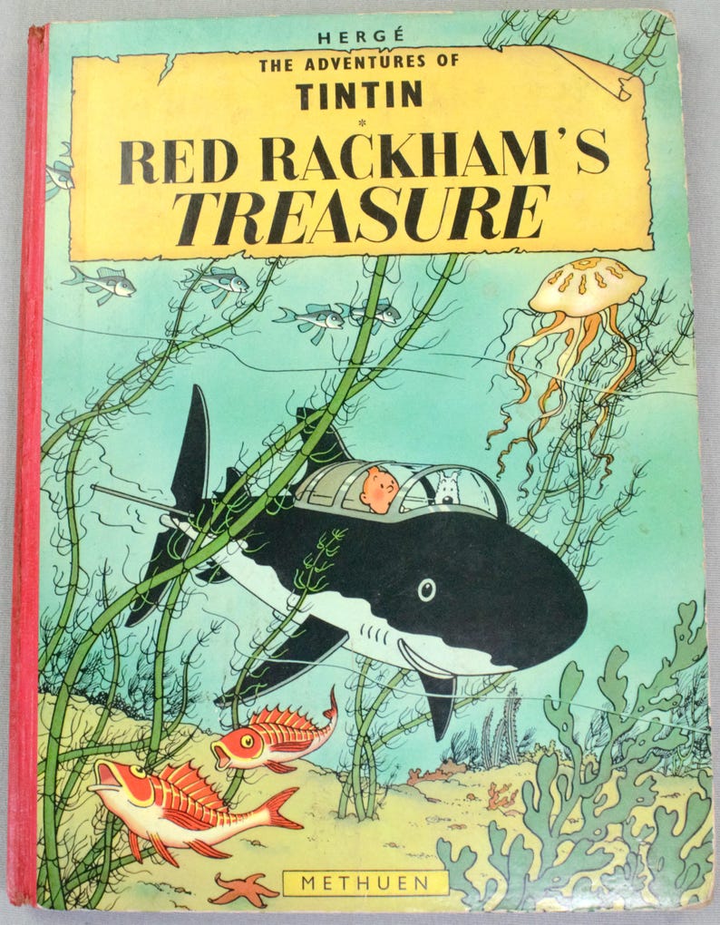 May include: A vintage copy of "Red Rackham's Treasure" by Herg&eacute;. The cover features a shark-shaped submarine with Tintin and Snowy inside, swimming underwater with fish and seaweed. The title is in large, bold letters.