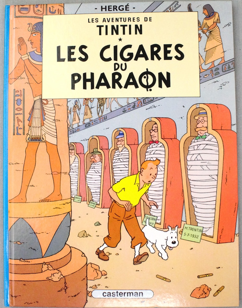 Pode incluir: Capa de "Os Charutos do Fara&oacute;" de Herg&eacute;. Tintin, com camisa amarela e cal&ccedil;as castanhas, e o seu c&atilde;o Milu s&atilde;o retratados. O t&iacute;tulo est&aacute; em letras pretas grandes. M&uacute;mias em sarc&oacute;fagos vermelhos.