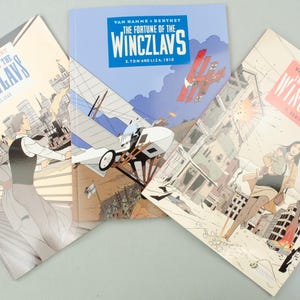 May include: Three comic books titled "The Fortune of the Winczlavs" are displayed. The covers feature illustrations of characters, vintage aircraft, and cityscapes. The color palette includes blues, reds, and beige, with text visible on each cover.