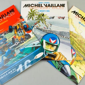 May include: Three comic books featuring the character Michel Vaillant and his legendary races. The covers display vibrant illustrations of race cars in action, with titles like "In the Hell of Indianapolis" and "A Driver's Soul."
