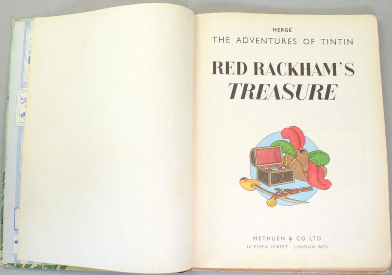 May include: An open book with the title "Red Rackham's Treasure" by Herg&eacute;. The cover features an illustration of a treasure chest, feathers, and other items. The book is from Methuen & Co Ltd.