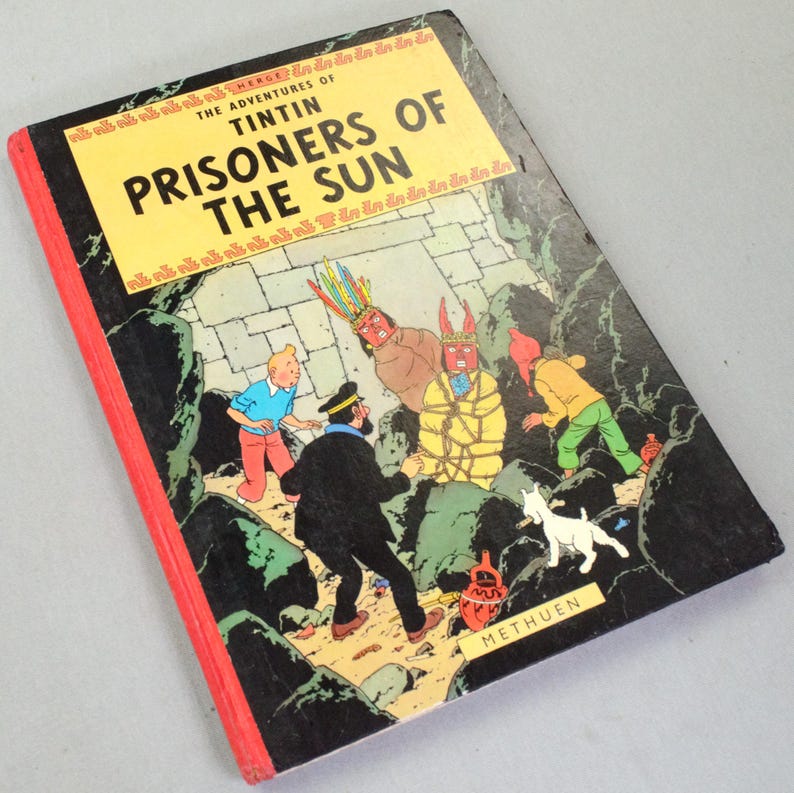 Op de afbeelding: Een vintage exemplaar van "De avonturen van Kuifje: De Zonnetempel" stripboek. De cover toont een kleurrijke illustratie van Kuifje, Kapitein Haddock en andere personages in een jungle-omgeving. Het boek heeft een gele titelbanner en een rode rug.