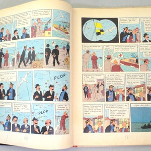 Op de afbeelding: Open boek met stripverhaal illustraties. De pagina's tonen panelen met tekeningen van mensen, boten en tekstballonnen. De strip is in kleur, met een vintage stijl. Het boek is open op pagina's 4 en 5.
