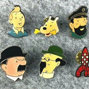 以下が含まれることがあります： タンタンの漫画シリーズのキャラクターをフィーチャーした6つのエナメルピンのコレクション。ピンはタンタン、スノーウィー、ハドック船長、デュポン、カラス教授、ロケットを描いています。各ピンは金色の裏地が付いています。