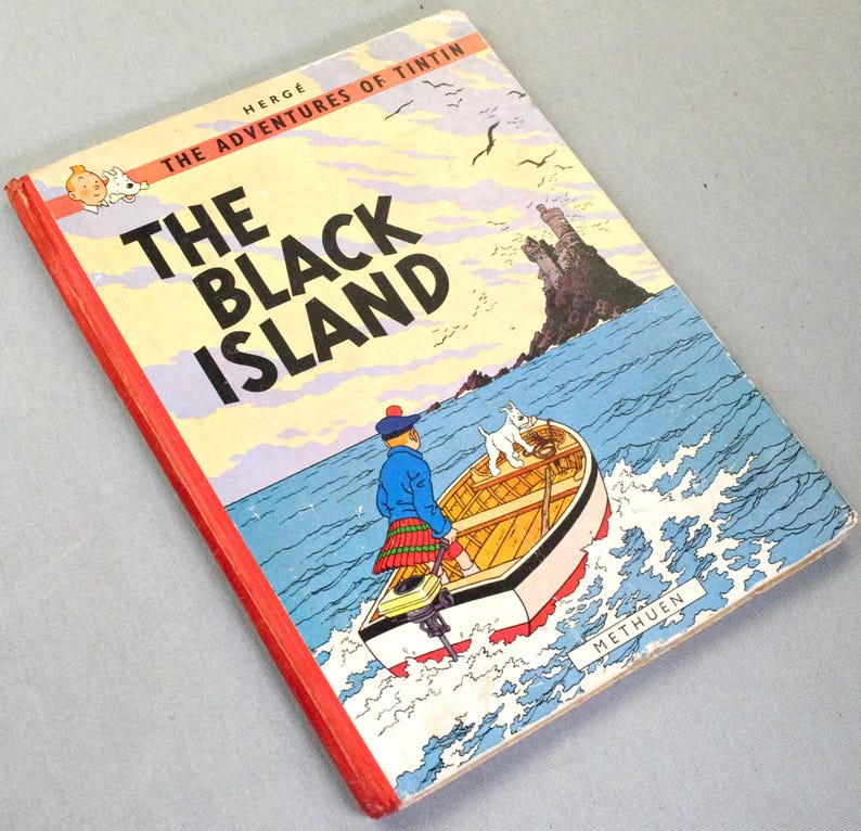 K&ouml;nnte beinhalten: Ein Vintage-Exemplar von Herg&eacute;s "Die Schwarze Insel". Das Cover zeigt Tim und Struppi in einem Boot, mit einer K&uuml;stenszene und einer Burg. Das Buch hat einen roten Buchr&uuml;cken.