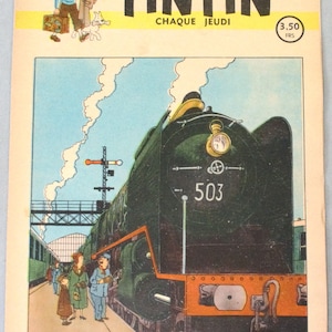 May include: A vintage Tintin comic magazine cover dated 21 November 1946, featuring a large green steam locomotive numbered 503 at a train station. The illustration shows a family standing on the platform, with the text Tintin Chaque Jeudi.