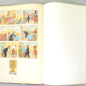 Op de afbeelding: Een open boek met stripverhalen met kleurrijke illustraties en tekstballonnen. De panelen tonen sc&egrave;nes met personages in verschillende omgevingen. De tekst "THE END" is zichtbaar onderaan de pagina.