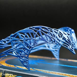 May include: A blue, 3D printed, intricate, decorative headband with a delicate, lacy design. The headband is made of a lightweight material and has a delicate, feminine feel.