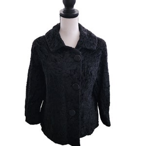 May include: A black faux fur jacket with a collar and three black buttons down the front.