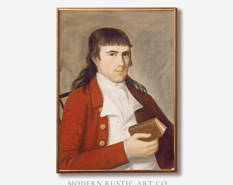 May include: A framed portrait painting of a person with dark hair wearing a red coat over a white collared shirt and cravat, holding a small brown book. The text MODERN RUSTIC ART CO. VINTAGE REIMAGINED is printed in black below the framed artwork.