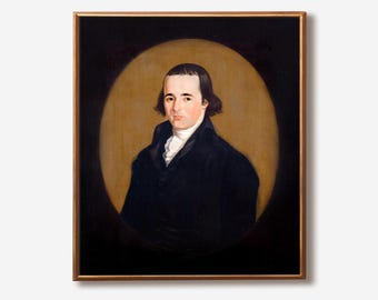 May include: A framed portrait of a man in a black coat and white shirt. The painting features a gold frame and a dark background with a golden oval around the subject's head and shoulders. The man has dark hair and a serious expression.